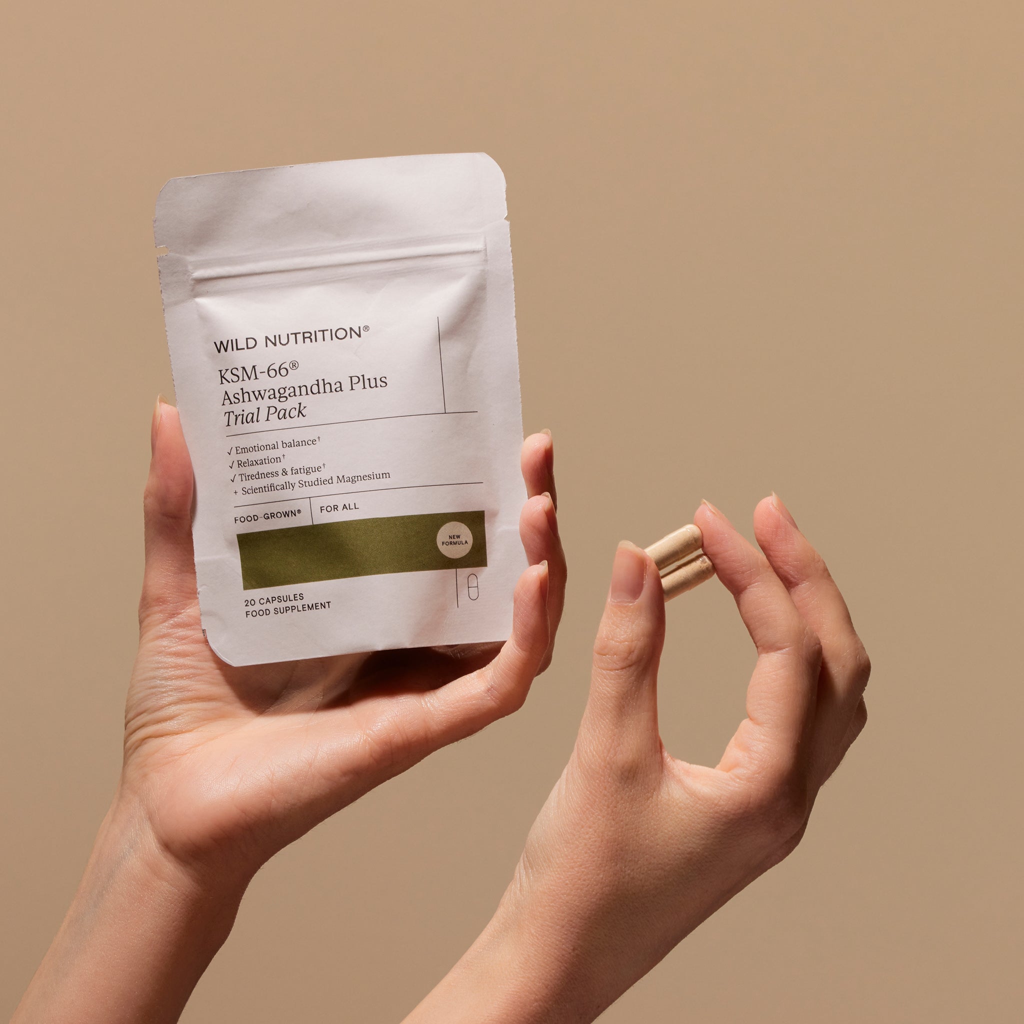 A person's hands holding a packet labeled 'Wild Nutrition KSM-66 Ashwagandha trial pack' 