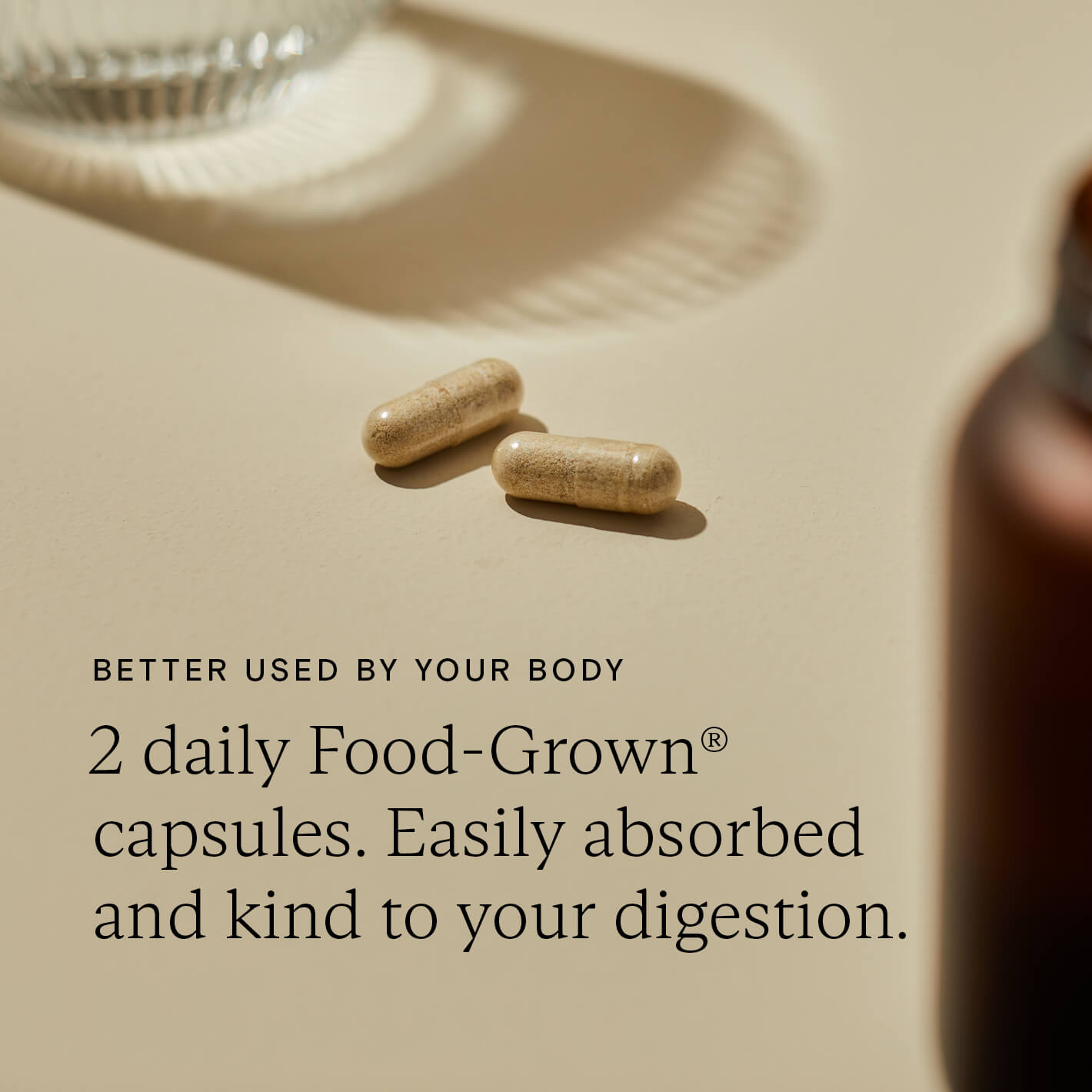 Two Food-Grown capsules on a surface, highlighting their easy absorption and gentle effect on digestion.
