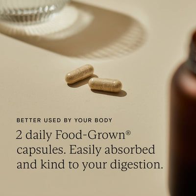 Two Food-Grown capsules on a surface, highlighting their easy absorption and gentle effect on digestion.