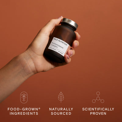 Hand holding a jar of perimenopause complex supplements