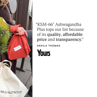 Person holding a red bag with a quote about KSM-66 Ashwagandha Plus on a white background.