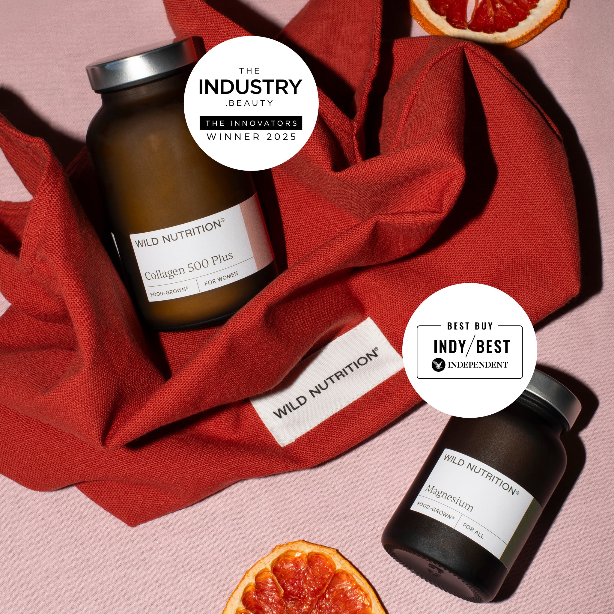 Two bottles of Wild Nutrition supplements (collagen and magnesium) on a red fabric background with 'The Industry Beauty' and 'Best Buy Indy' labels.