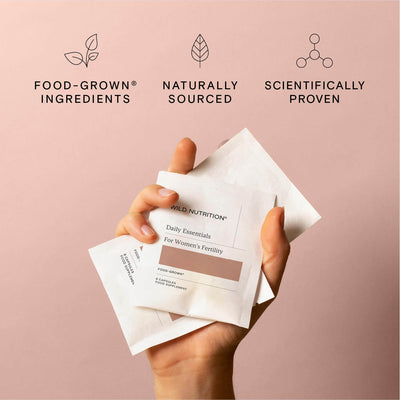 Hand holding sachets of Daily essentials for women's fertility