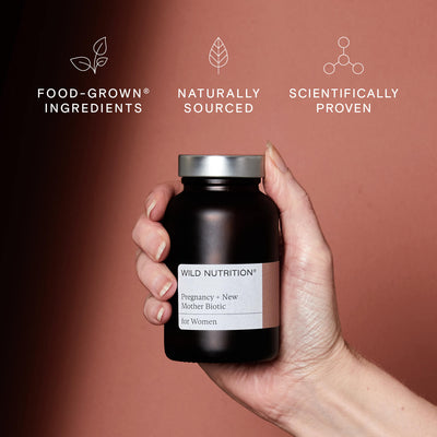 A hand holding a jar of Pregnancy + New Mother Biotic supplements - Food-Grown®, naturally sourced and scientifically proven